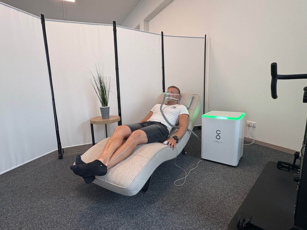 Mann entspannt auf Liege mit Atemmaske beim Zelltraining, ideal für effektives Beckenbodentraining und gesundheitliche Regeneration.