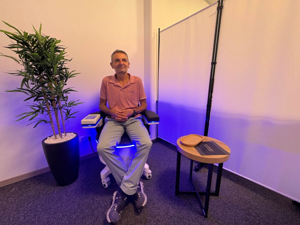 Mann beim Beckenbodentraining in modernem Studio, umgeben von Pflanzen und entspannten Farben, unterstützt Zelltraining.